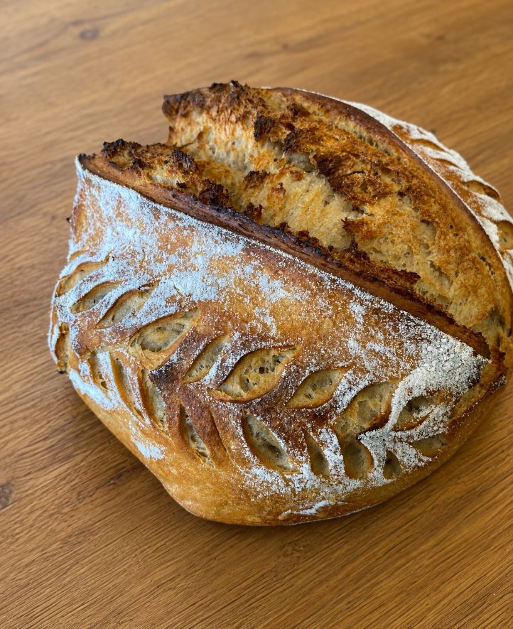 Plain sourdough boule, scored and cut open to show the crumb
