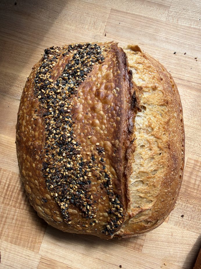 Everything-but-the-bagel sourdough loaf with a seeded crust